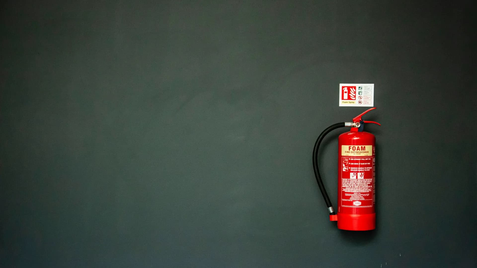 An engineer testing a fire extinguisher in a commercial kitchen
